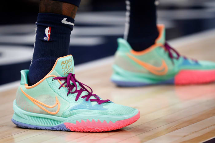 View of teal and pink Nike Kyrie Low 4 sneakers.
